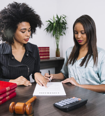 african-american-woman-pointing-document-near-lady-with-pen-table
